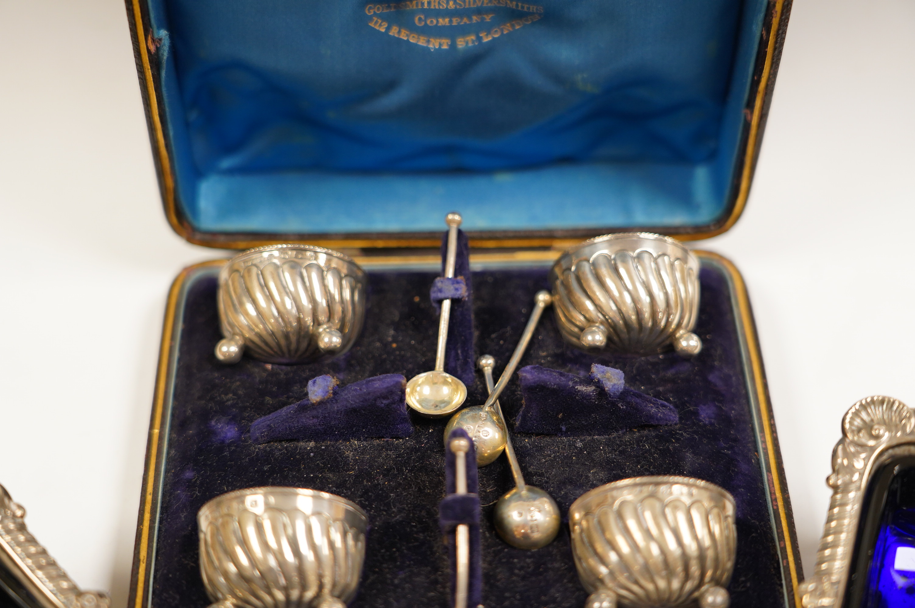 A pair of late Victorian silver rectangular salts, Hawksworth, Eyre & Co, London, 1897, 91mm with blue glass liners and a cased set of four Victorian silver tub salts with spoons. Condition - fair